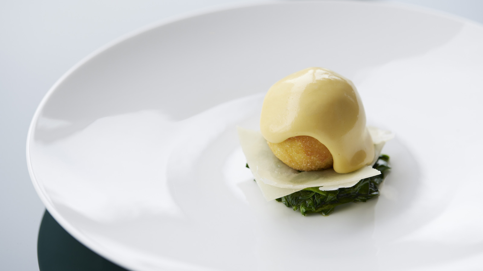 Egg Hollandaise is made with organic eggs from Yamanashi and served on a bed of comté cheese and baby leaf spinach. MAISON MARUNOUCHI Four Seasons Hotel Tokyo at Marunouchi