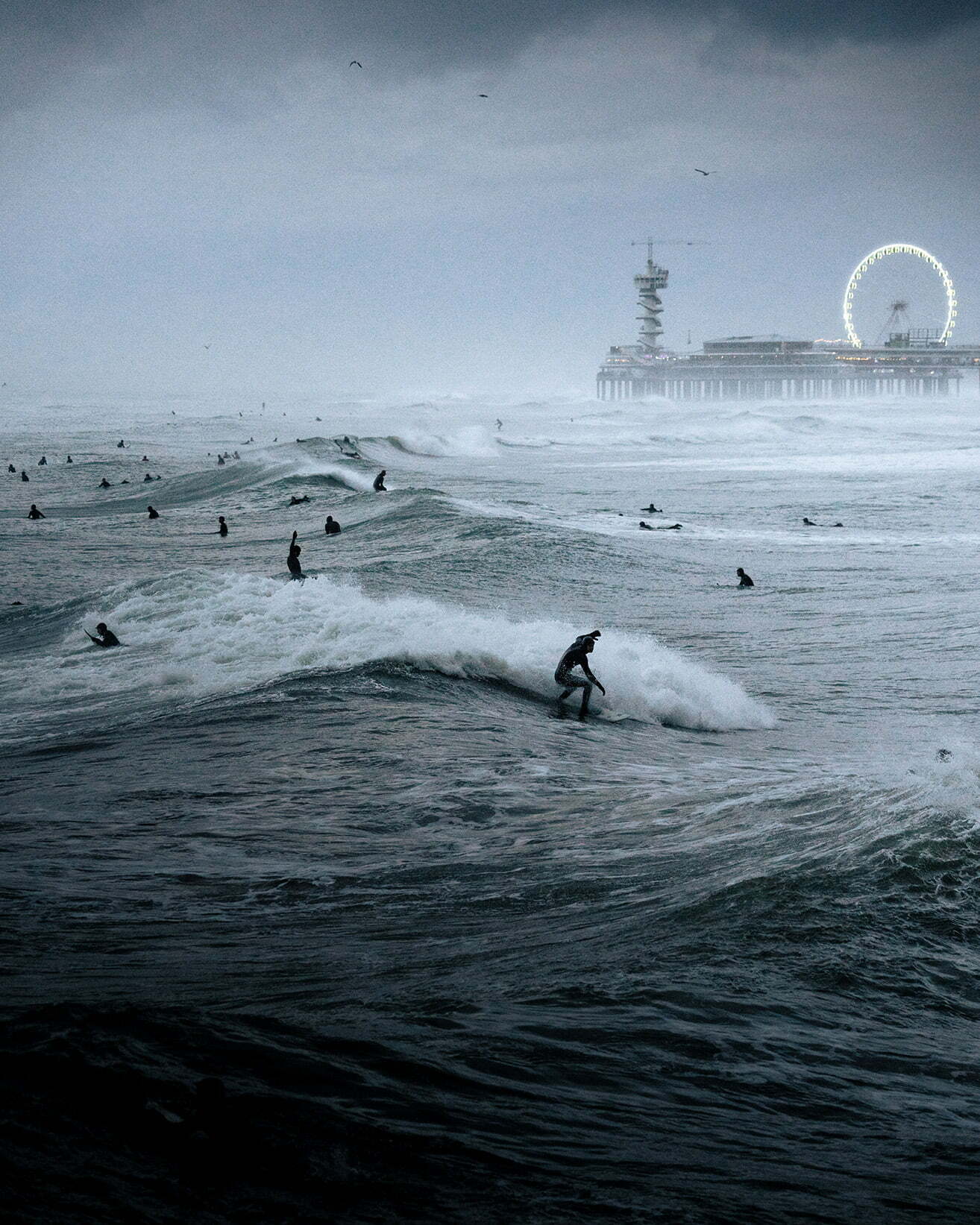 Surfing Festival - Photographer Name: Raido Nurk. The waves were the biggest I’ve ever seen in the evening when I took this photo in The Hague, Netherlands. The waves and the pouring rain created quite a unique atmosphere. Copyright: © Raido Nurk, Estonia, Winner, Open, Motion, 2022 Sony World Photography Awards