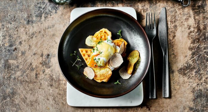 Beer and wheat waffles with poached egg, cheese cream, spring truffles, and potato chips.