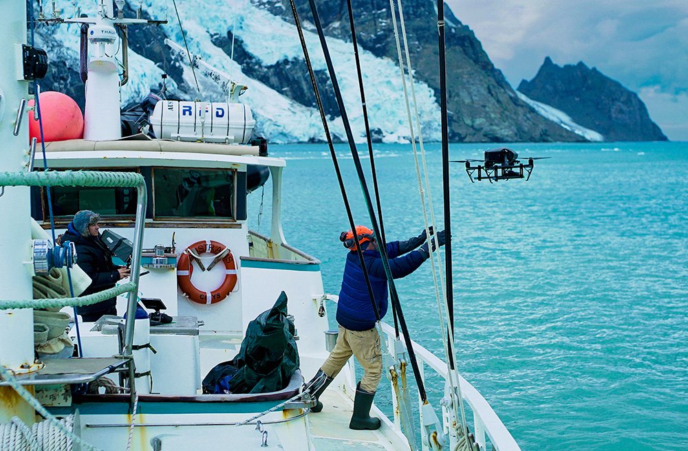 Crew prepares to recover a drone after a filming flight. Toàn thể nhân viên chuẩn bị thu hồi máy bay không người lái sau chuyến bay quay phim
