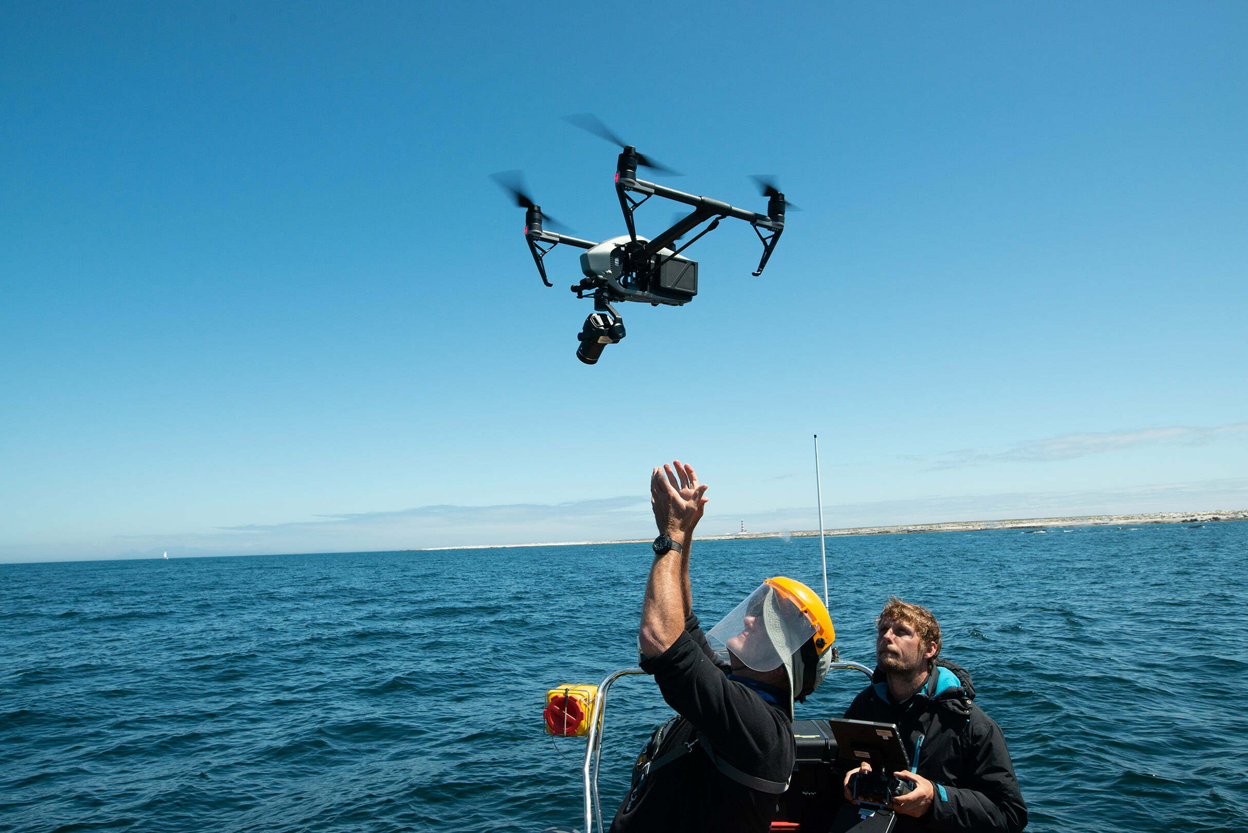 Drone operator catching a drone on a boat. 