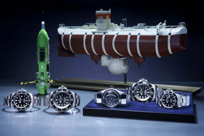 Foreground, left to right: Oyster Perpetual Rolex Deepsea (2008), Oyster Perpetual Deepsea Challenge (2022), Deep Sea Special (1960), Rolex Deepsea (2012) and Oyster Perpetual Submariner (1986). Background, left to right: models of the DEEPSEA CHALLENGER submersible and the bathyscape Trieste.