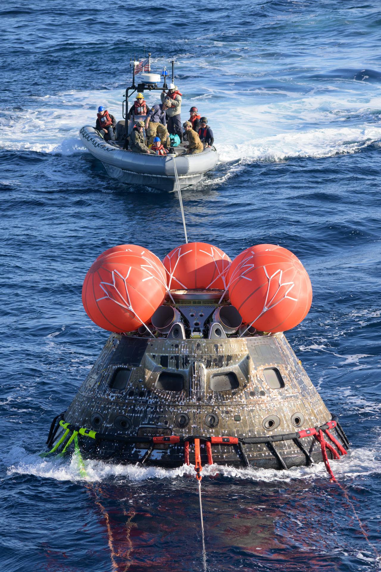 After splashing down at 12:40 p.m. EST on Dec. 11, 2022, U.S. Navy divers help recover the Orion Spacecraft for the Artemis I mission. NASA, the Navy and other Department of Defense partners worked together to secure the spacecraft inside the well deck of USS Portland approximately five hours after Orion splashed down in the Pacific Ocean off the coast of California.