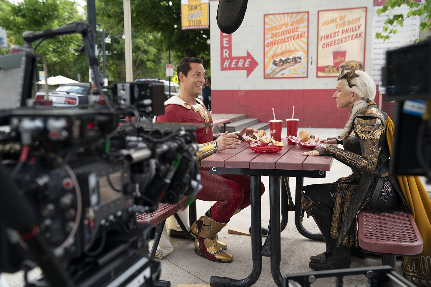 (L-r) ZACHARY LEVI and Helen Mirren on the set of New Line Cinema’s action adventure “SHAZAM! FURY OF THE GODS,” a Warner Bros. Pictures release.