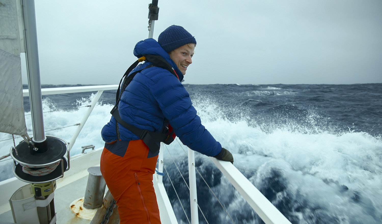 Bertie Gregory on board the Australis, looking over the edge of the ship.