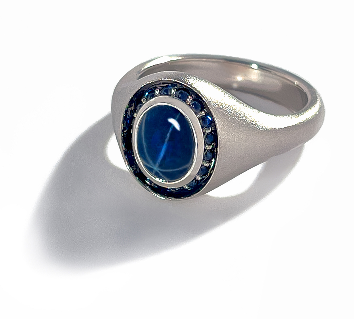 Bespoke Star Sapphire Ring by Geoffrey Good Star Sapphire Cabochon with small sapphire cabochons side-mounted and recessed in an all-platinum ring