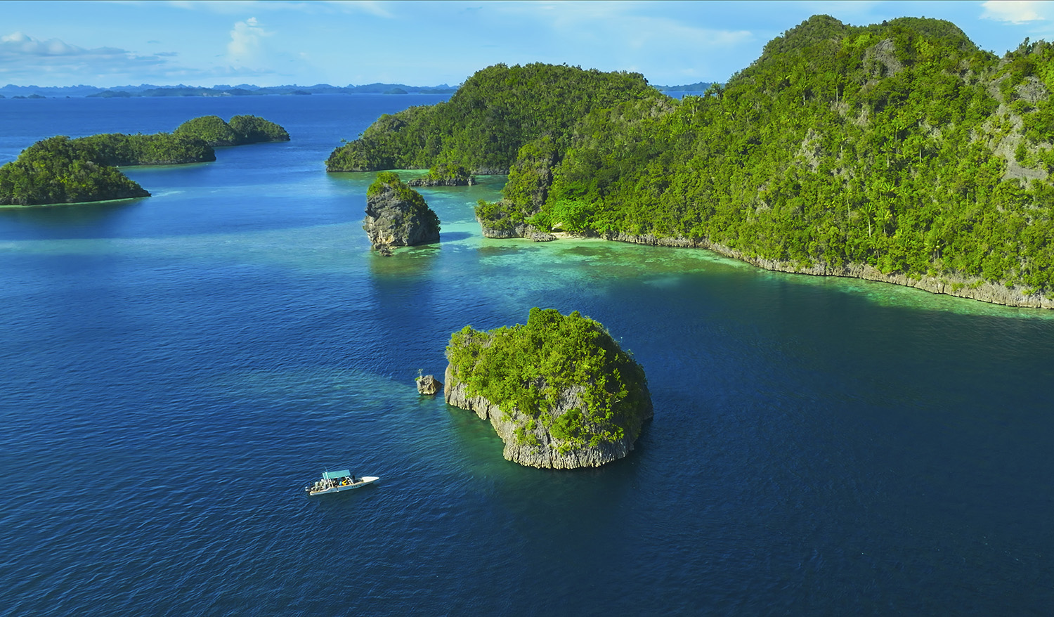 Aerial drone shot off the dive boat heading towards an island.