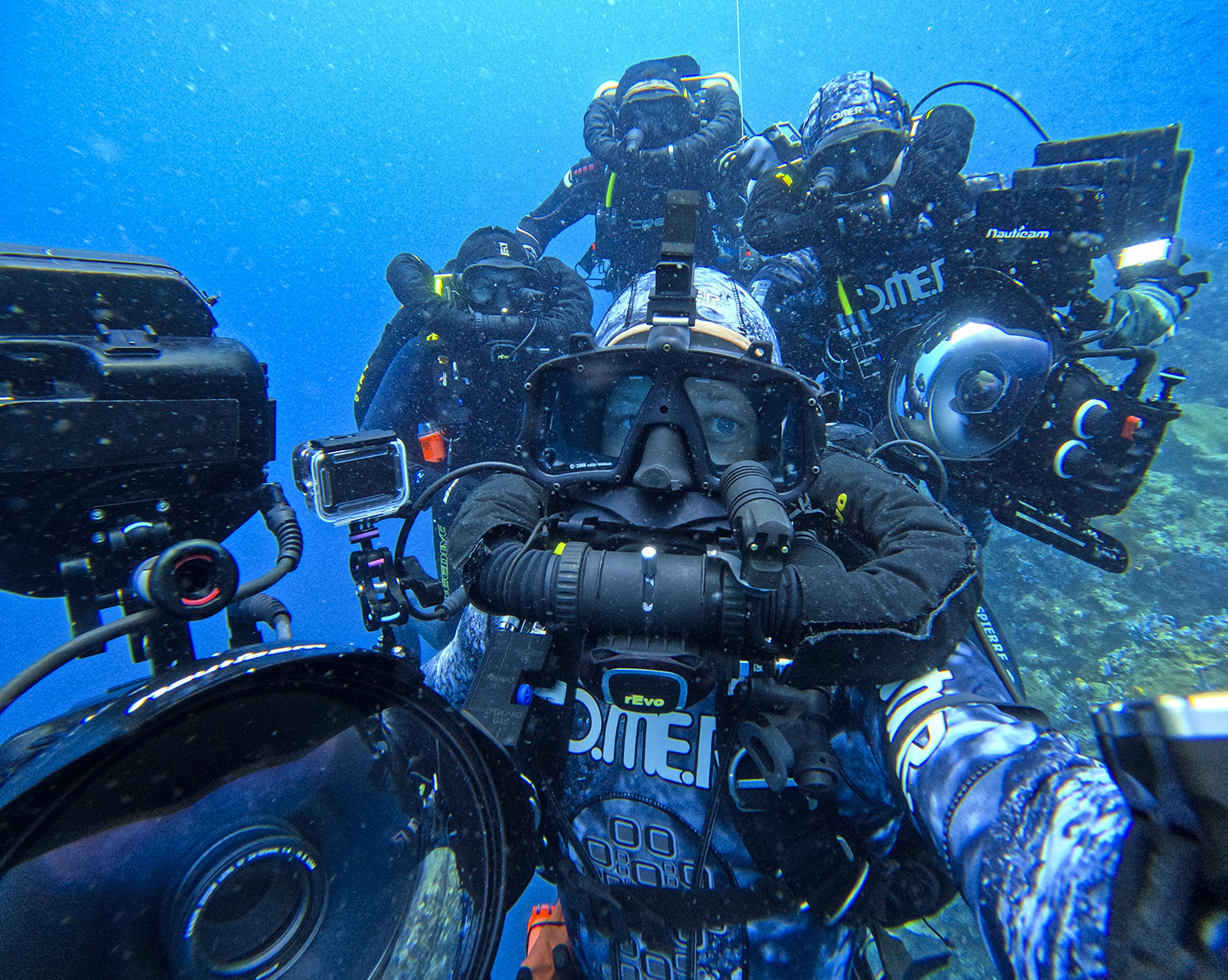 Bertie Gregory surrounded by the crew underwater.