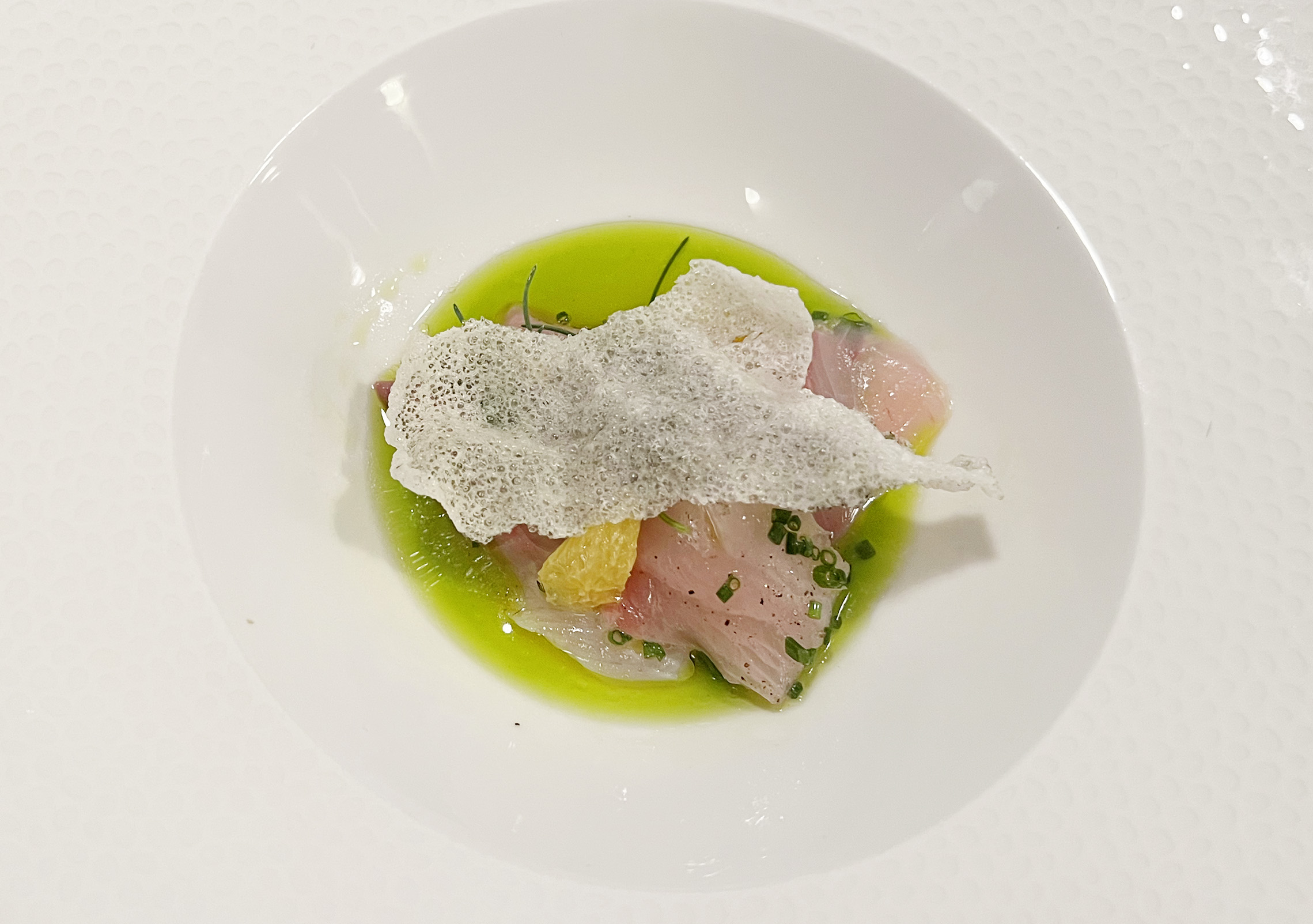 Yellowtail Crudo, a citrusy delight featuring seagrass, rice cracker, and sea grapes, paired with Kuro Kabuto, Muroka, Junmai Daiginjo at Kali Restaurant in Los Angeles (Photo by Julie Nguyen)