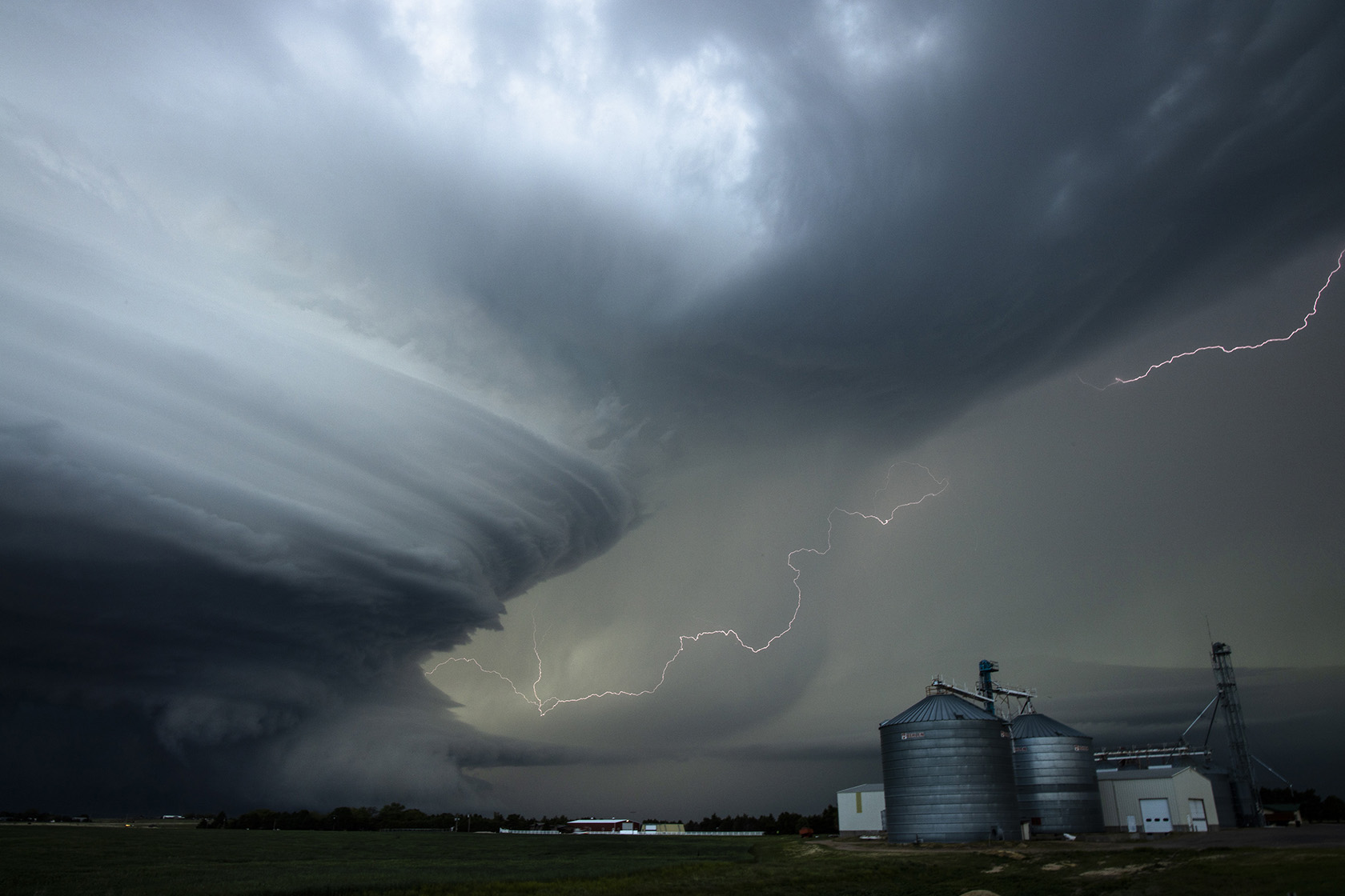 A 'supercell' storm towers over a farm grain elevator in Nebraska, USA.