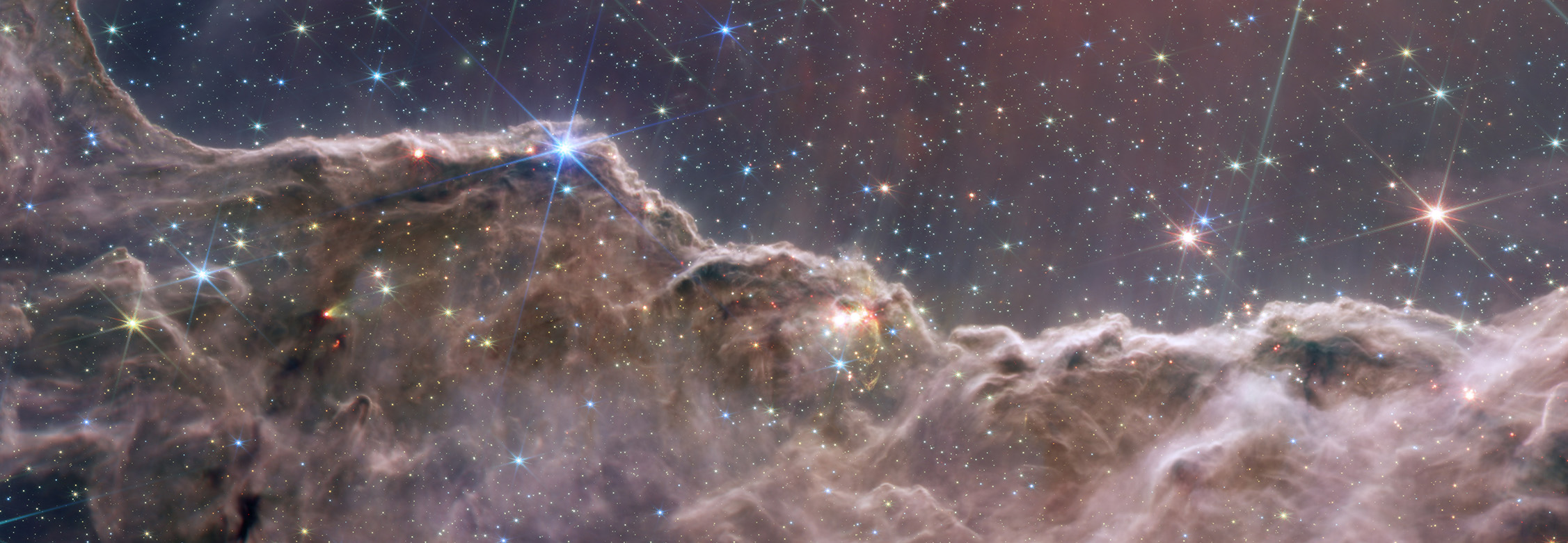 Astronomers using JWST combined the capabilities of the telescope’s two cameras to create a never-before-seen view of a star-forming region in the Carina Nebula. Captured in infrared light by the Near-Infrared Camera (NIRCam) and Mid-Infrared Instrument (MIRI), this combined image reveals previously invisible areas of star birth. 