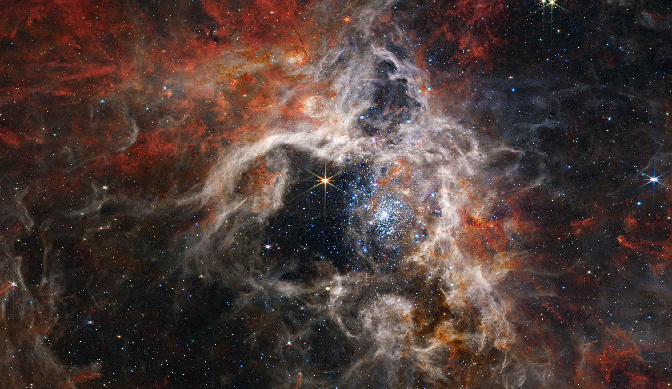 Featured in the IMAX® documentary DEEP SKY, this mosaic image stretches 340 light-years across. JWST’s Near-Infrared Camera (NIRCam) displays the Tarantula Nebula star-forming region in a new light, including tens of thousands of never-before-seen young stars that were previously shrouded in cosmic dust.
