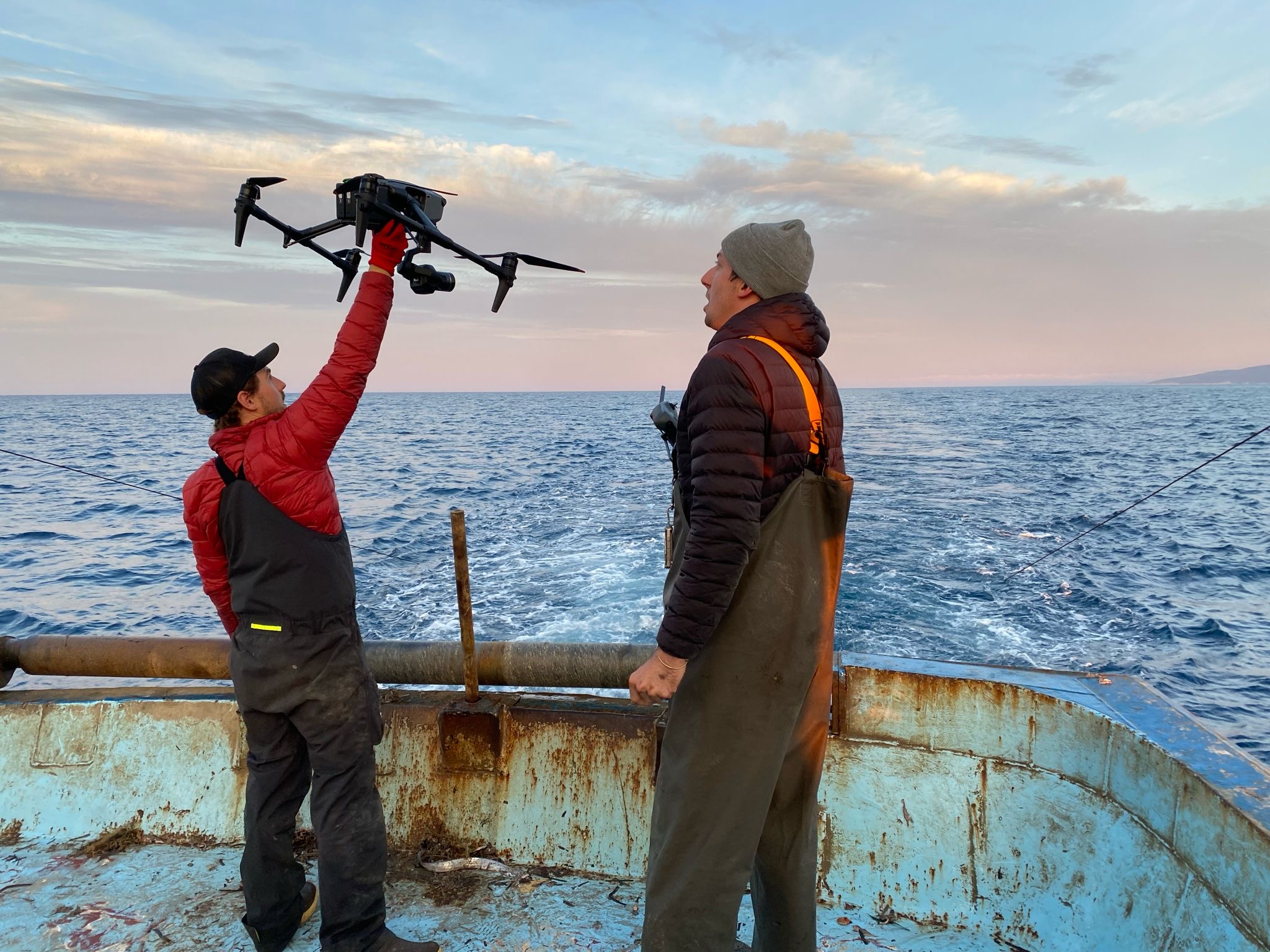 Alex Warham and Jacca Deeble launch a drone to film footage of an ocean trawler.