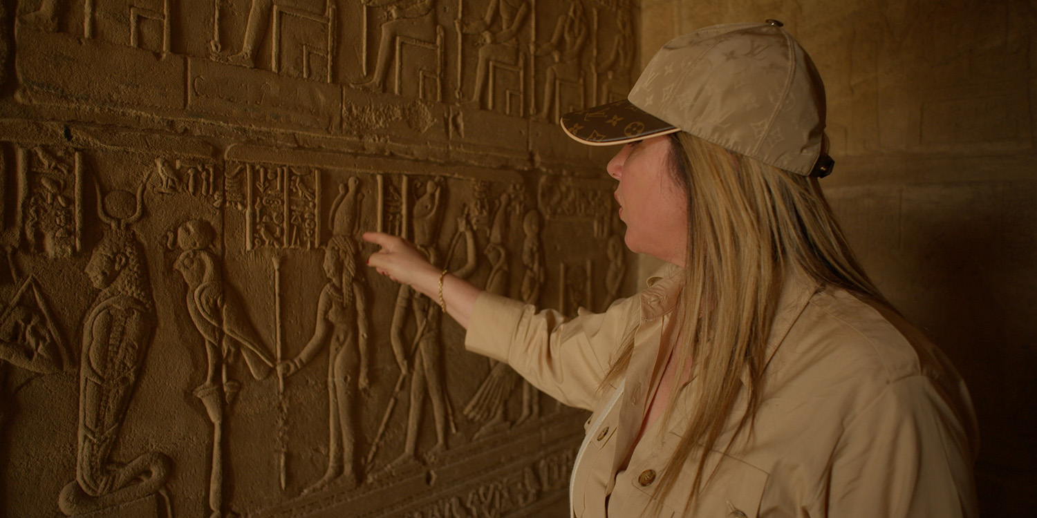 Kathleen Martinez gesturing towards hieroglyphics on the wall.