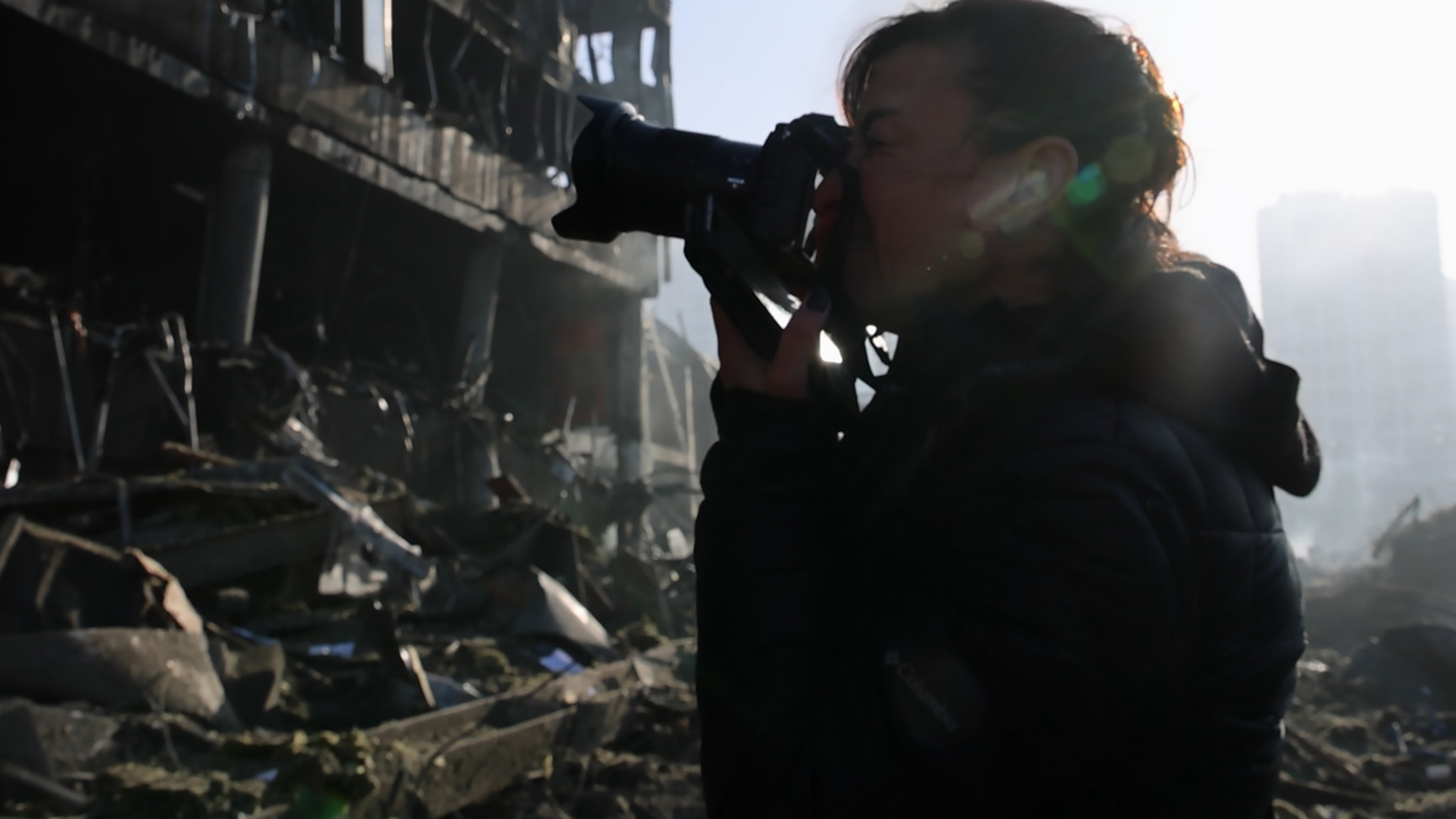 Lynsey Addario photographs a damaged building in Ukraine. 