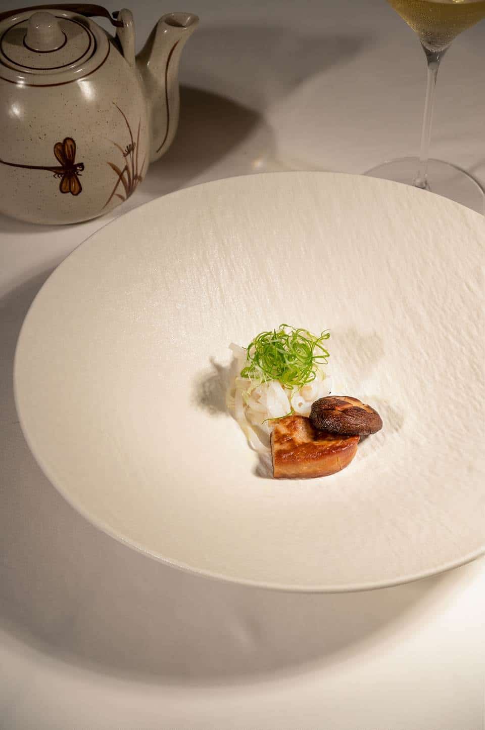 Foie gras phở consommé layered with shiitake mushrooms and a thread of truffle oil - The Anam Mui Ne